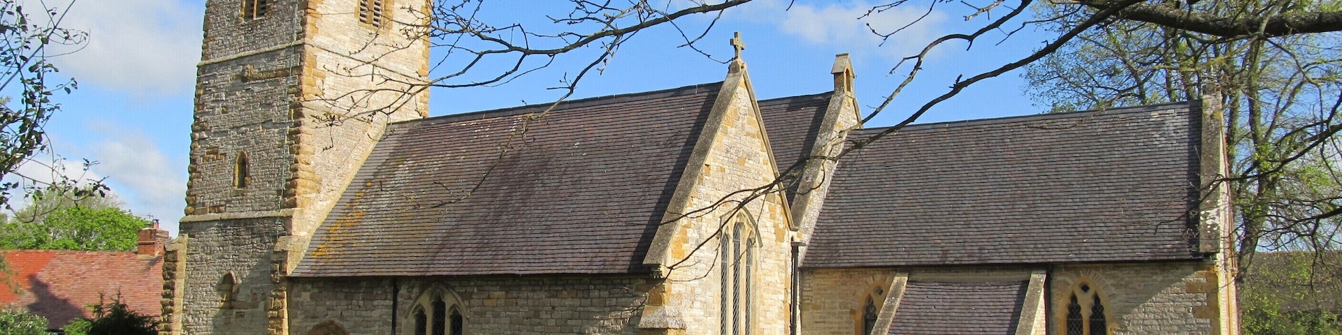 A historic church with a tall tower and a graveyard in front.