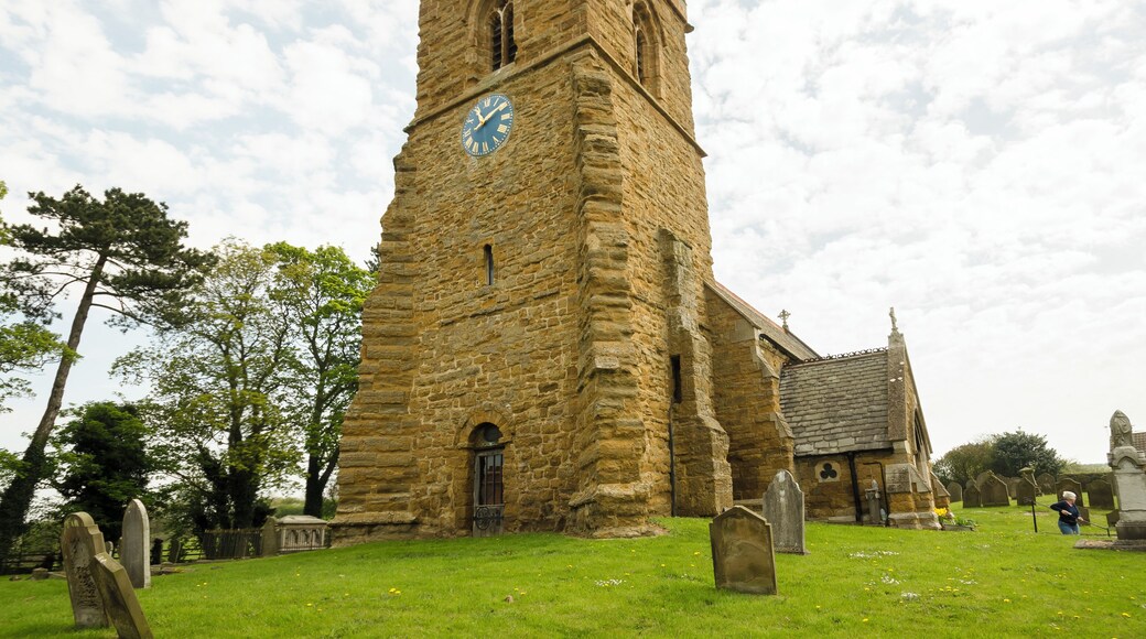 This ironstone church dates back to the 11th century and was restored in 1805 and 1874. There is a western tower, nave, chancel, vestry, and south porch. The west tower is Saxo-Norman, the ironstone being very weathered. The top part is 15th century, having a plain parapet with 19th-century pinnacles. There are three bells. The tower was restored in 2011. The tower arch is tall and was restored in the 1500s. The Royal coat of arms above it dates from post 1837, and is made of cast metal. Most of the rest of the church dates from the 1874 rebuilding with some mediaeval masonry retained. On the outside of the chancel wall is an early 12th century panel with various geometrical decorations. The fittings are all 19th-century, and the floor is paved with Minton tiles. The small organ is by Cuthbert of Hull from 1877. There are several stained-glass windows, dating from after the time of the 1874 rebuild.
