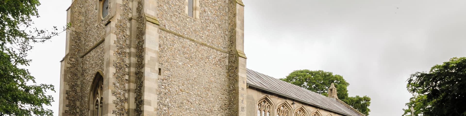 Grade I listed The church dates mainly from the 14th and 15th century, the west tower was rebuilt in 1864. There is a west tower, nave, chancel, north and south aisles and clerestory, north vestry, and south-west Chapel. The church is built in flint and stone with some checker work. The tower has an embattled parapet with crocketted pinnacles, the octagonal tower Lantern was added in the 19th century. The east end of the nave has a small Sanctus bellcote on the roof. The nave has north and south aisles of four bays with further bays for the north Chapel. The clerestory was added in the 15th century. There is a fine 15th century hammerbeam roof with carved Angels and original colouring. In the chancel, there is a 19th-century reredos with a painting of "The raising of Lazarus". The east window has glass by De la Roche of Paris, 1844. The pulpit is octagonal, with tester from 1636, and there is a 14th century piscina in the north east Chapel. There are several brasses in the church, however these are covered by carpet. The interior of the church has been whitewashed, including the coved chancel ceiling. There is a small two manual organ which was installed in 1990.