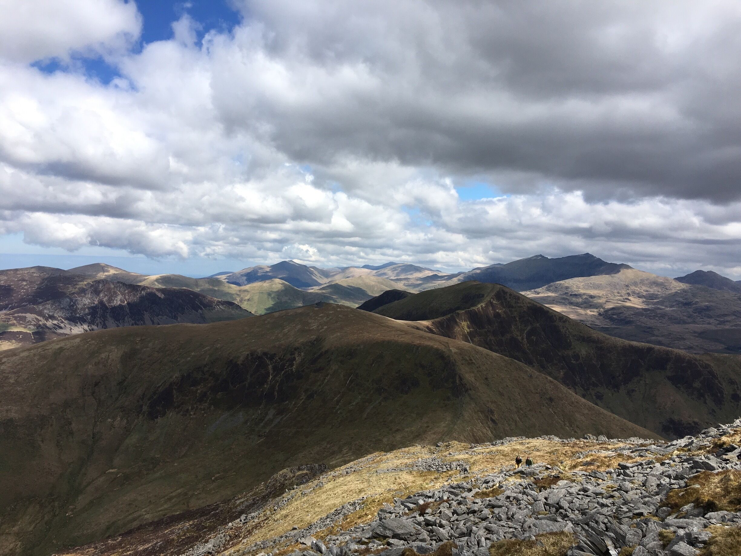 A mountainous landscape with rolling hills and a cloudy sky.