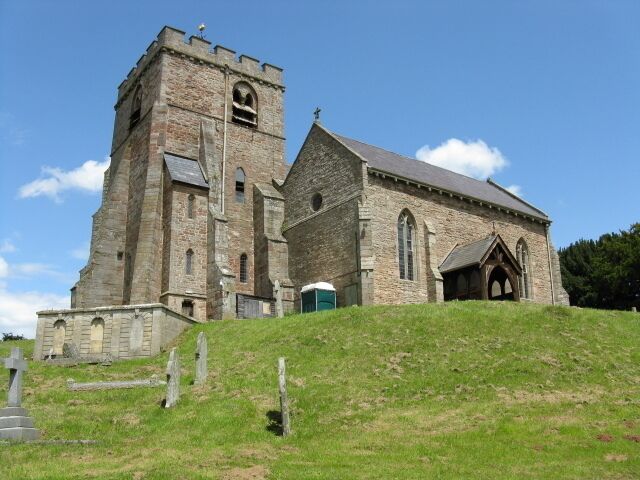 A historic stone church with a bell tower and a green door.