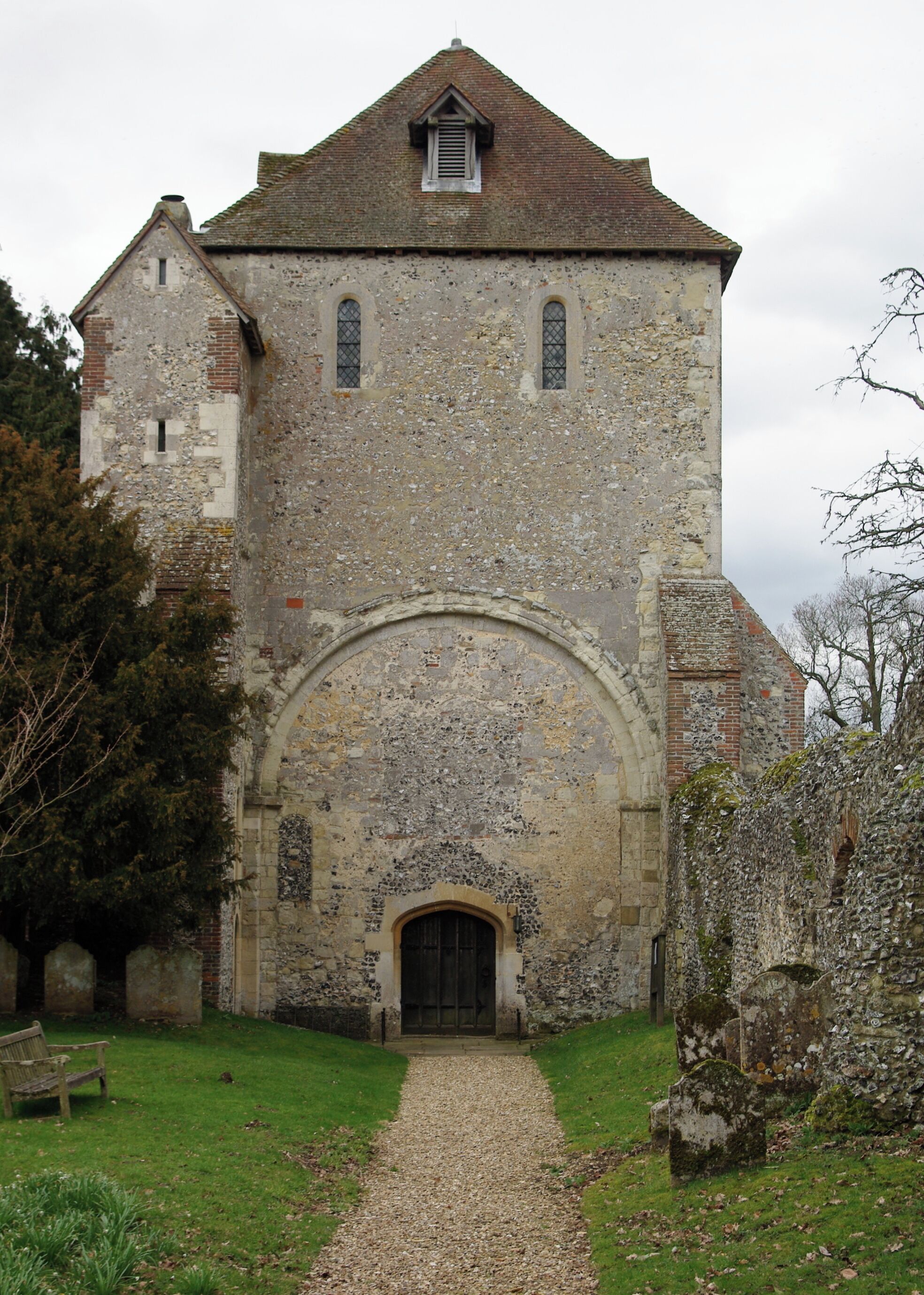 A historic stone church with a central arched doorway and a small bell tower.