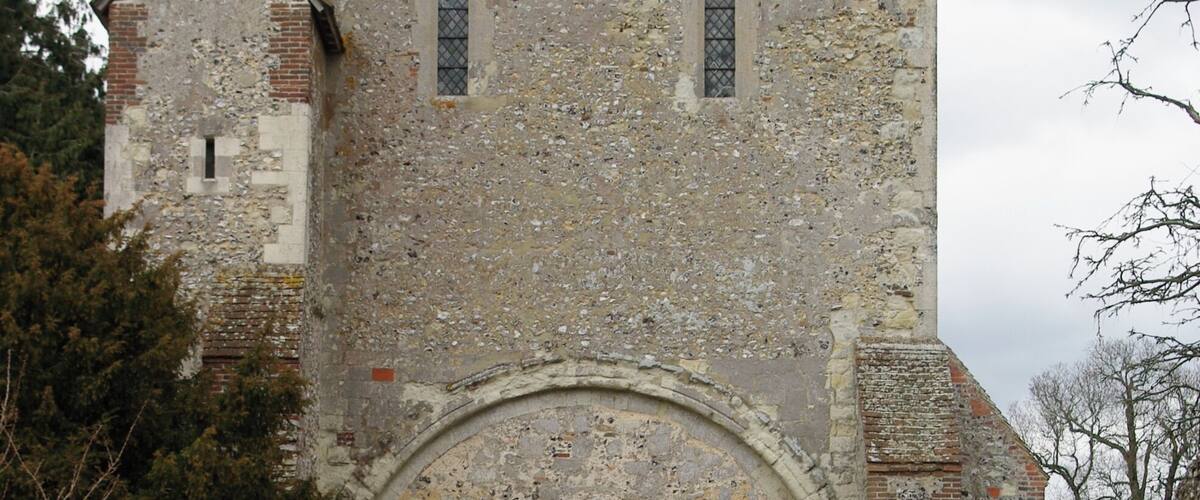 A historic stone church with a central arched doorway and a small bell tower.