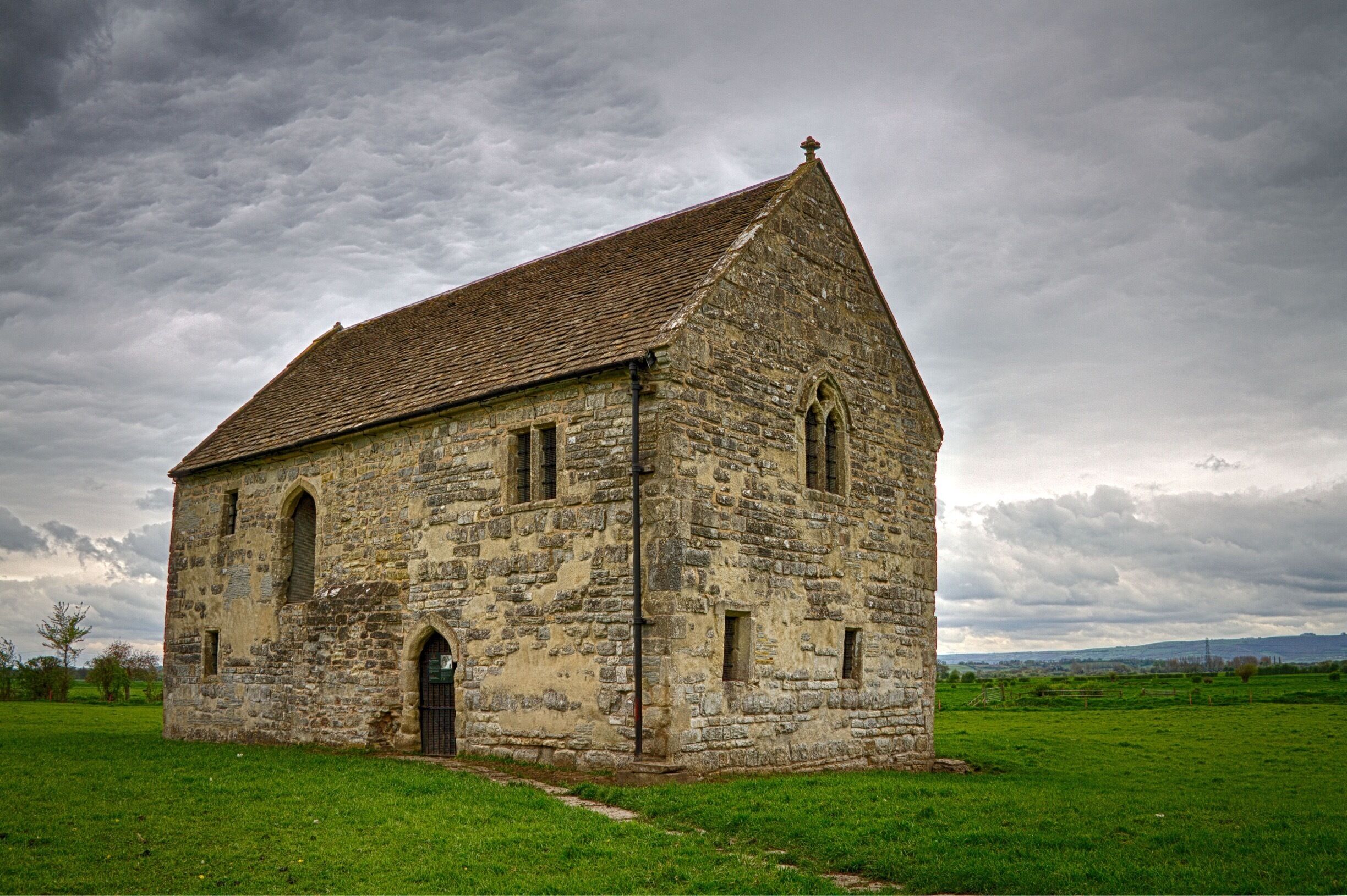 A stone church with a steep roof and arched windows.