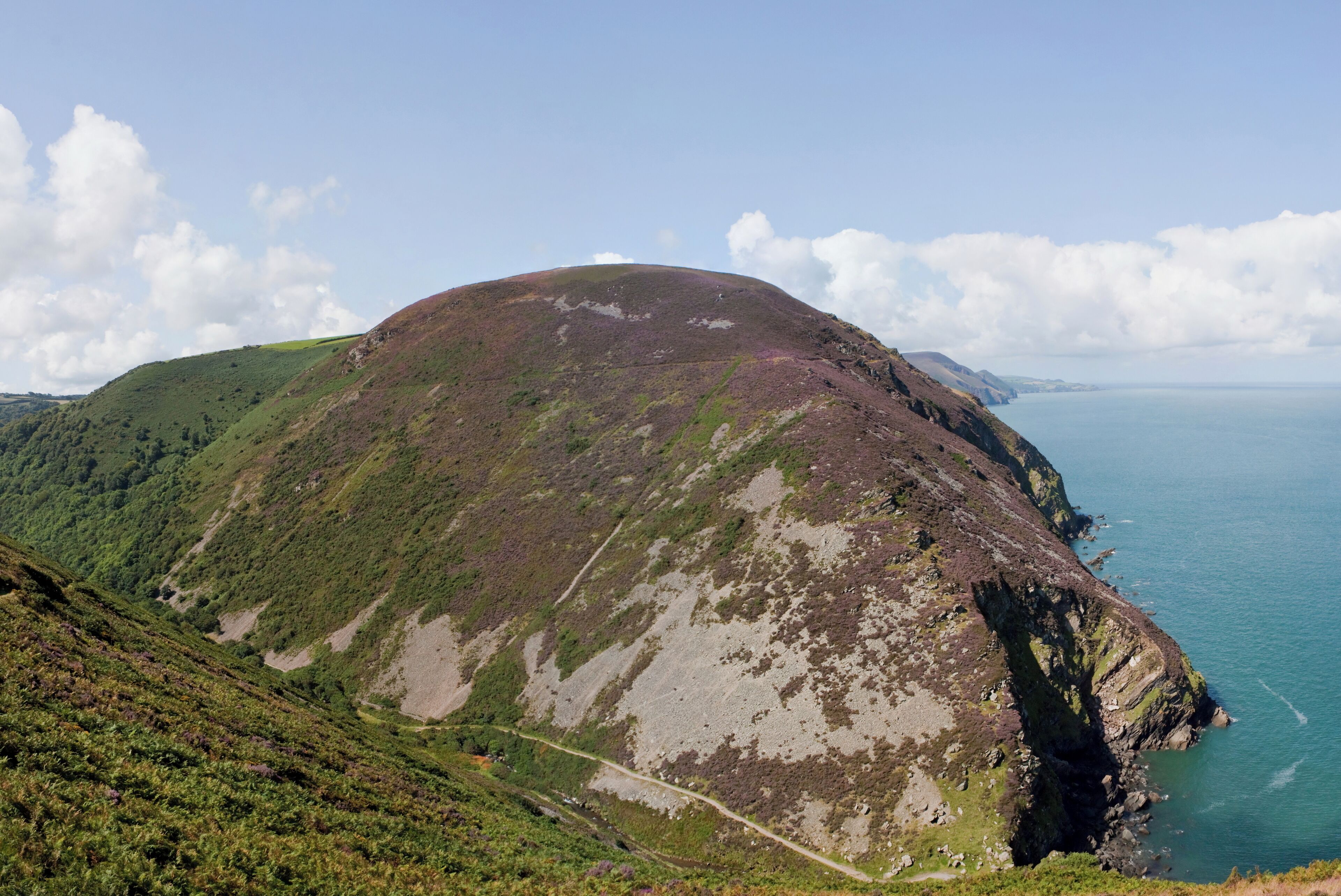 A coastal mountain with a winding path.
