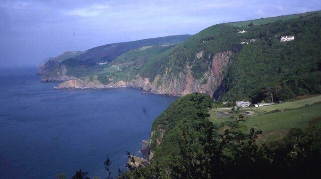 North Devon coast at Woody Bay In the foreground Martinhoe Manor sits in a clearing in the woods. In the background are The Valley of the Rocks and Foreland Point.