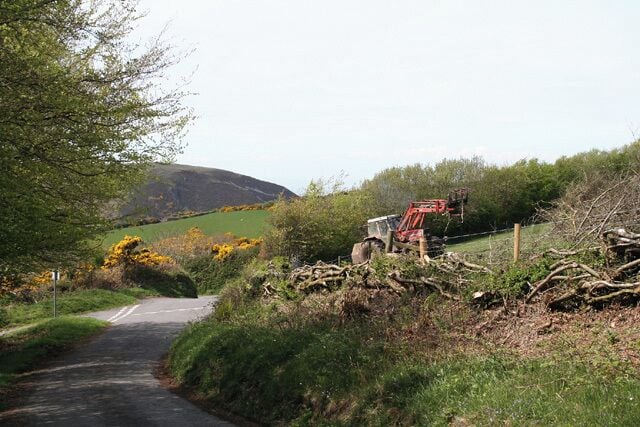 Martinhoe: near Mannacott Lane Head. Looking north west. The tractor is clearing brush away from the recently trimmed hedge