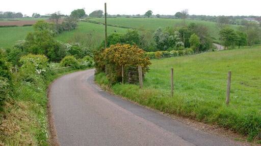 Lane to Marston Montgomery This narrow lane snakes across the peaceful undulating countryside of south west Derbyshire, here dropping down into the valley of one of the many tiny tributaries of the Dove.