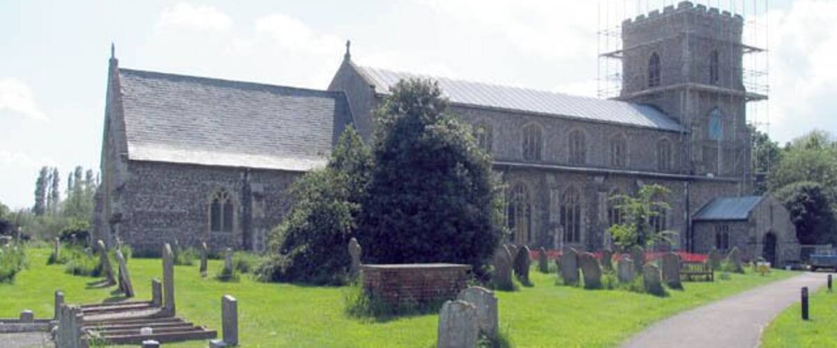 A church with a stone facade, a tower, and a graveyard with headstones.