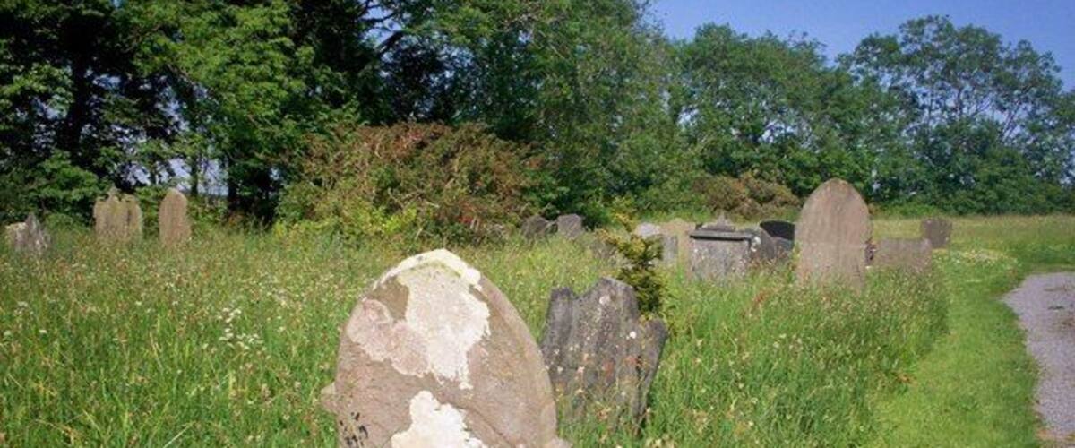 A rural cemetery with headstones and a gravel path.