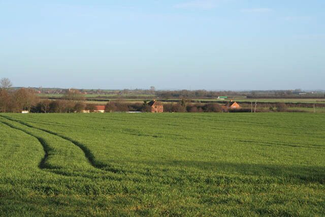 Farmland near Thackson's Well Farm The two buildings to the left and in the centre of the photograph are either side of Sewstern Lane. The building to the right is 301193. You can just make out a green lorry in the distance travelling north along the A1, Great North Road. Long Bennington can be seen in the fardistance to the left.