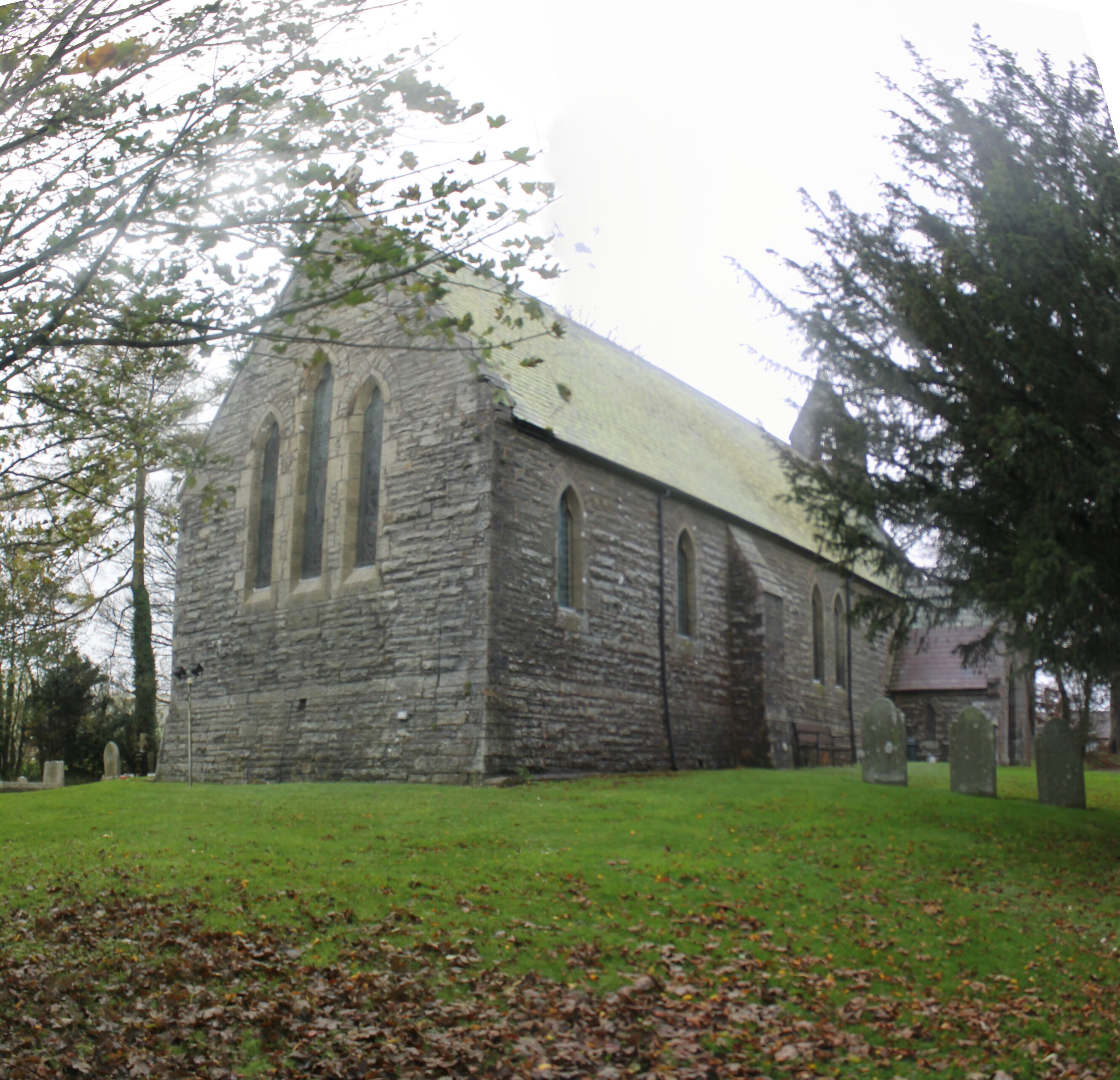A stone church with a steep roof and arched windows.