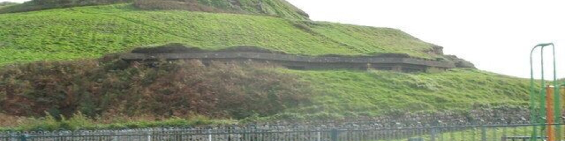 A Machine Gun Nest in an Iron Age Fort. This large pill box was constructed within the northern slope of this important Iron Age fort as part of the elaborate system of defences surrounding RAF Llandwrog. The beaches were also heavily mined. The railed off area in the foreground is a kiddies playground.