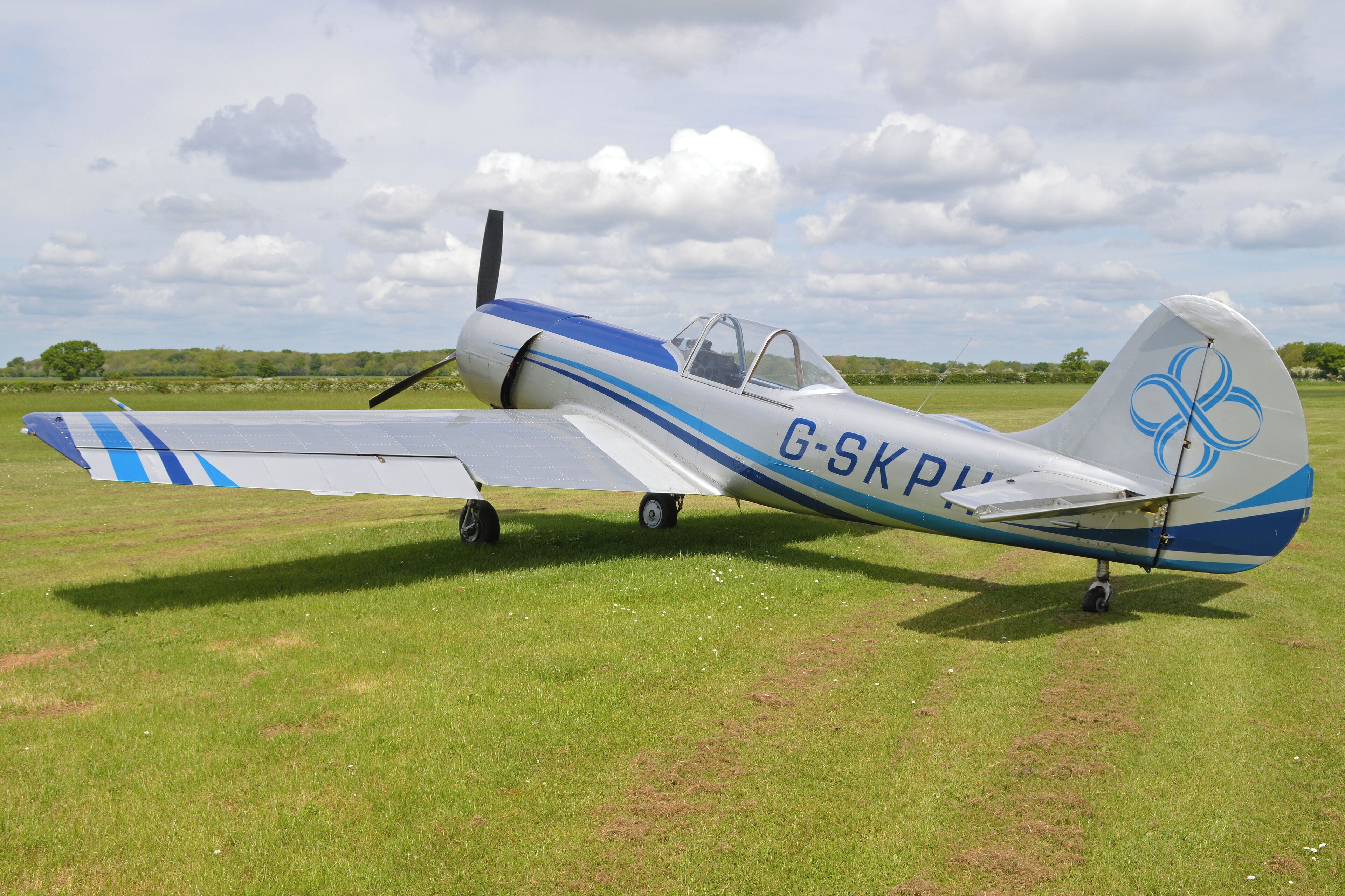 A small aircraft with registration G-SKP on a grassy field.