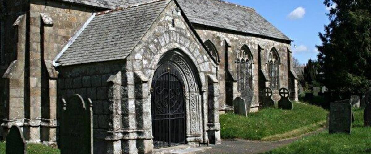 A stone church with a large arched entrance and a bell tower.