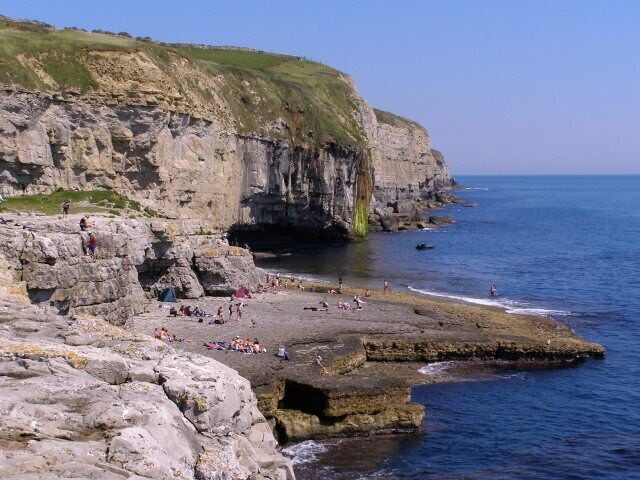 A rocky coastline with cliffs and a beach.