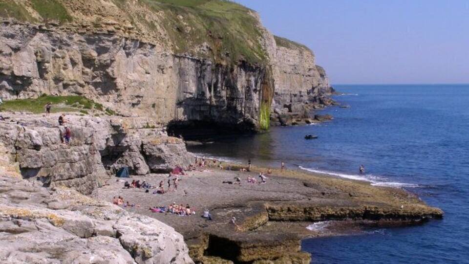 A rocky coastline with cliffs and a beach.