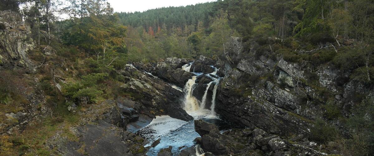 A waterfall cascading over rocks in a forested area.
