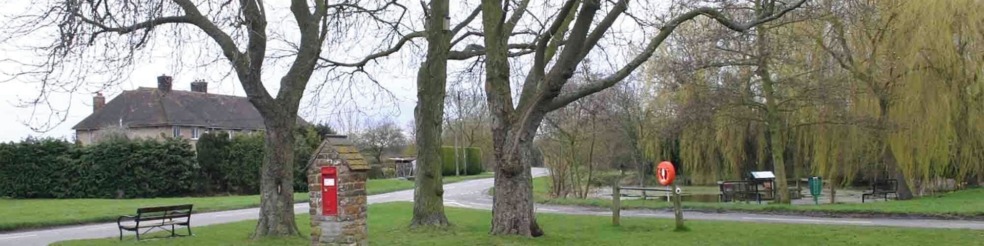 Village Green, Little Kineton. Looking south across the small village green with three trees and a victorian post box 1779449. The village pond 1779420 is visible behind the green on the right.