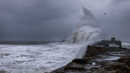 Un faro sobre un promontorio rocoso, con olas rompiendo contra él.