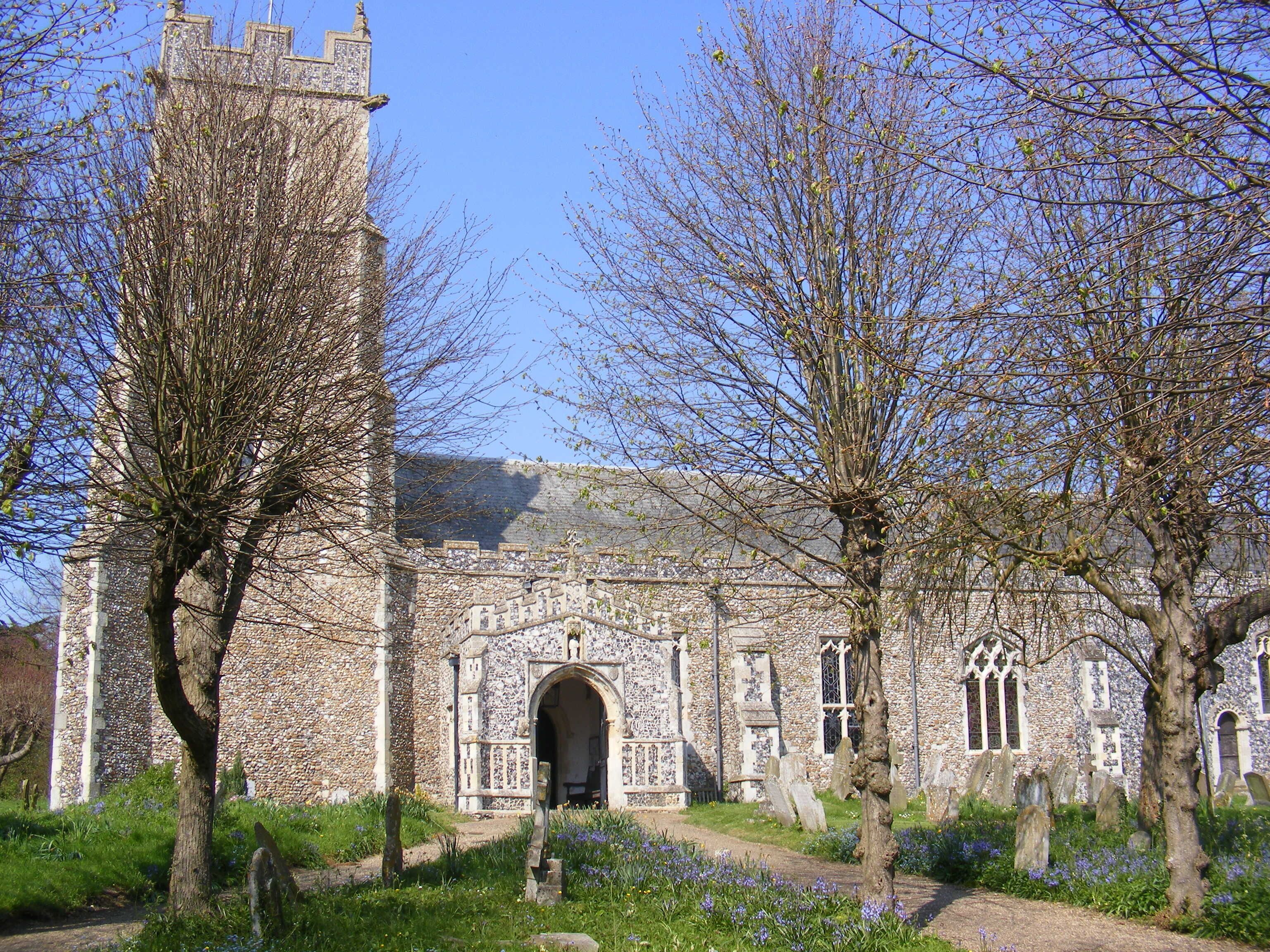 A historic stone church with a tall tower, arched entrance, and Gothic windows.