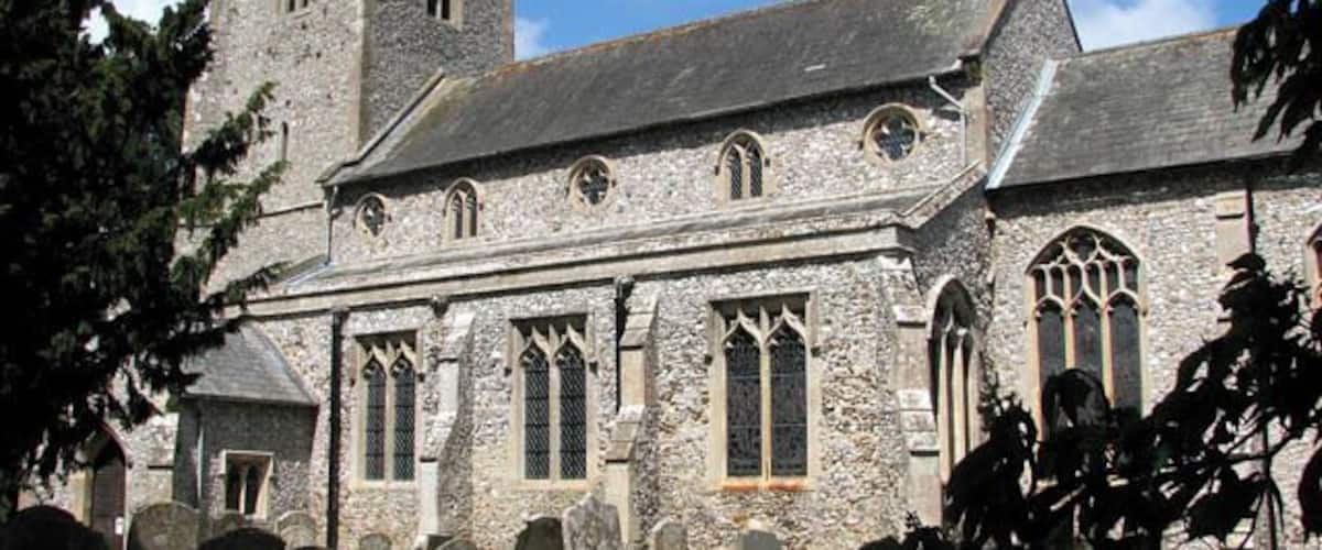 St Michael's church. St Michael's church is hemmed in by houses from all sides > 1300902 and difficult to reach. Although its tower can occasionally be glimpsed over roofs and through trees, there is only a narrow driveway > 1300904 and a short section of path leading to it. The churchyard contains a number of interesting old headstones and the remains of an ancient stone cross > 1300916 are situated right in front of the south porch > 1300909 which dates from the 15th century. The main body of the church > 1300908 was built a century earlier and the chancel wall contains lumps of carstone. The church interior > 1300927 - 1300941 was extensively restored by the architect G.E. Pritchett in the mid-19th century. It was during this time that the stained glass was put in many of the windows. According to the Norfolk churches website, St Michael's contains probably the best collection of late 19th and early 20th century glass of any small church in East Anglia > 1300958 - 1300968 - 1300974. Most of the stained glass windows were made in the workshop of the O'Connors and there is work by Robert Bayne and Christopher Webb. The originally square font has been cut at some state to form an octagon, ruining some of the carving > 1301005 - 1301020. The rood screen > 1300931 is also largely original albeit restored and covered with dark varnish. There is a three figure brass > 1301039 on the west tower wall which dates from 1623 and features Agnes Brigge and her parents. This church is kept locked but a key is available on request. http://www.norfolkchurches.co.uk/ingoldisthorpe/ingoldisthorpe.htm