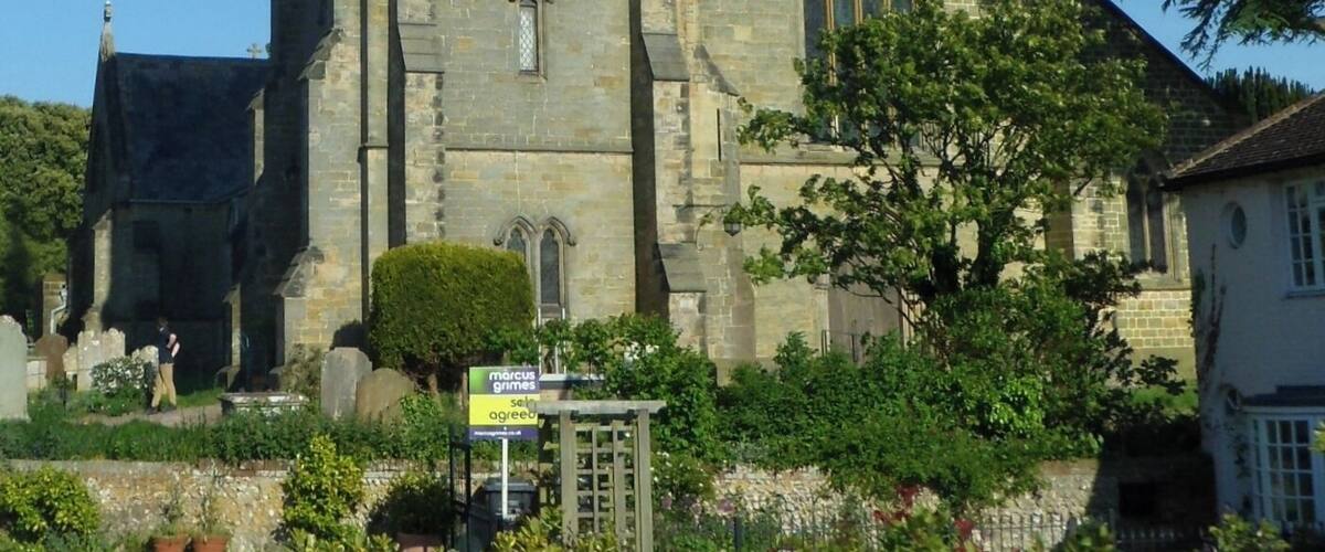 A church with a tall spire and a clock tower.