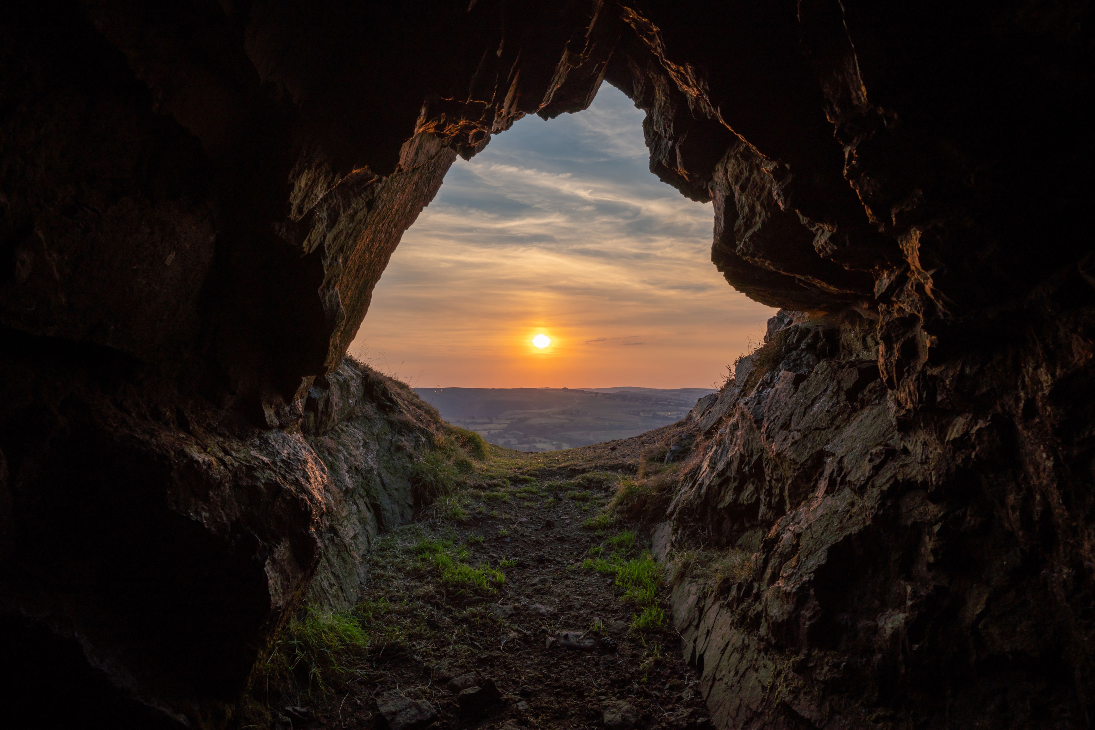 A rock arch with a sunset view.