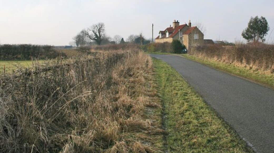Road between Gorse Lane and Stroxton. Lodge Farm East Cottage has commanding views across the Lincolnshire countryside. Lodge Farm is behind the trees in the centre of the photograph.