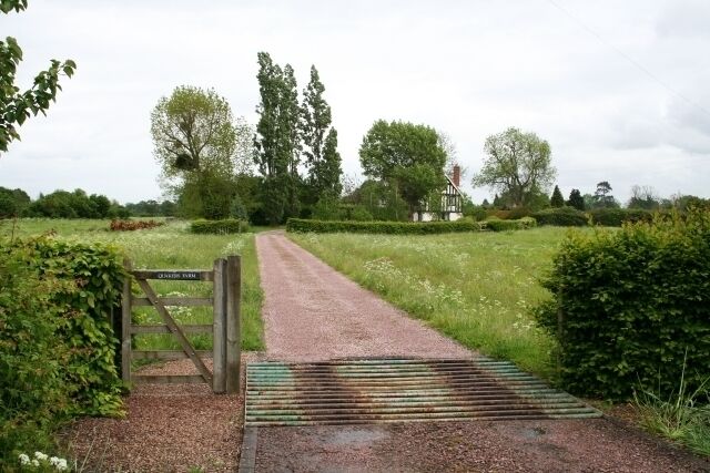 A gravel path leading to a gate labeled "Quarry House" with a metal ramp.