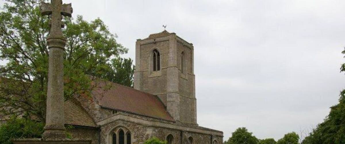 A church with a tall tower and a graveyard with headstones.