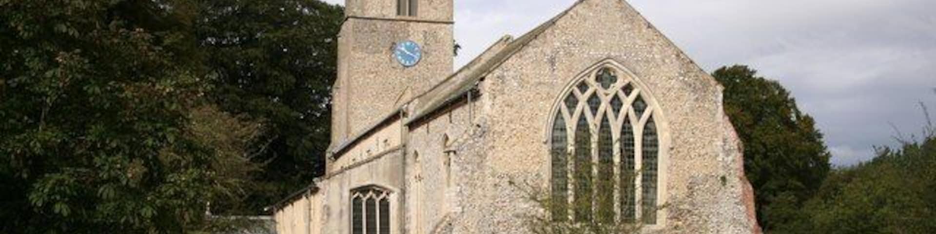 A historic church with a tall tower and large arched windows.