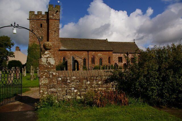 A historic church with a stone wall and a tower.