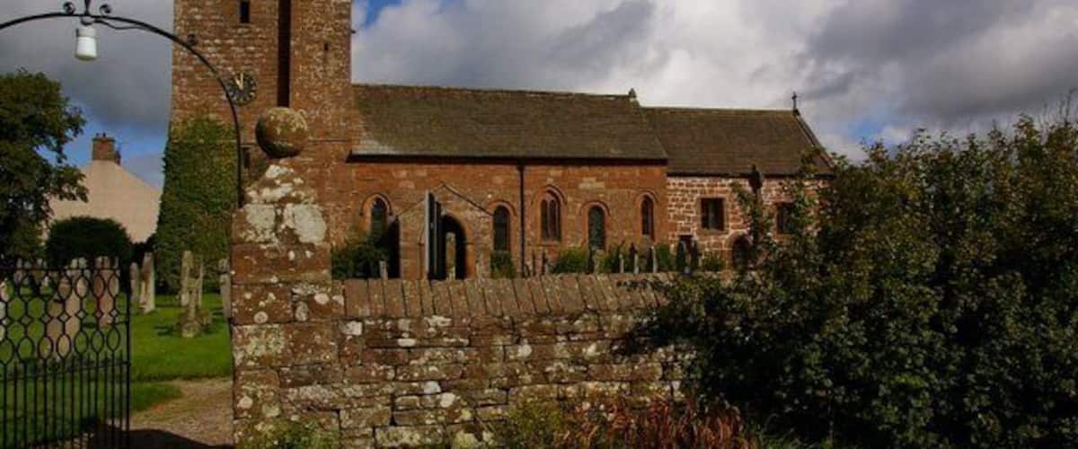 A historic church with a stone wall and a tower.