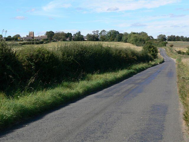 Middleton Road towards Bringhurst The tower belongs to the Church of St Nicholas.