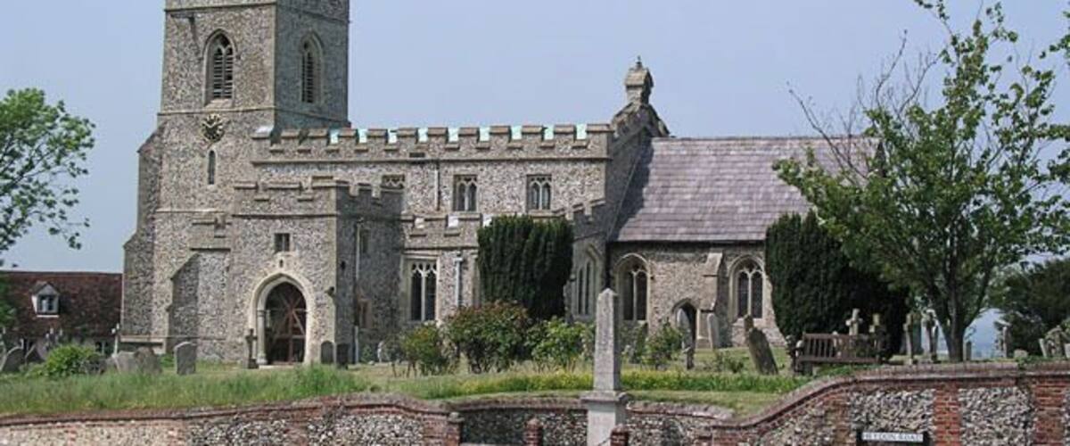 A historic stone church with a tower and arched windows.