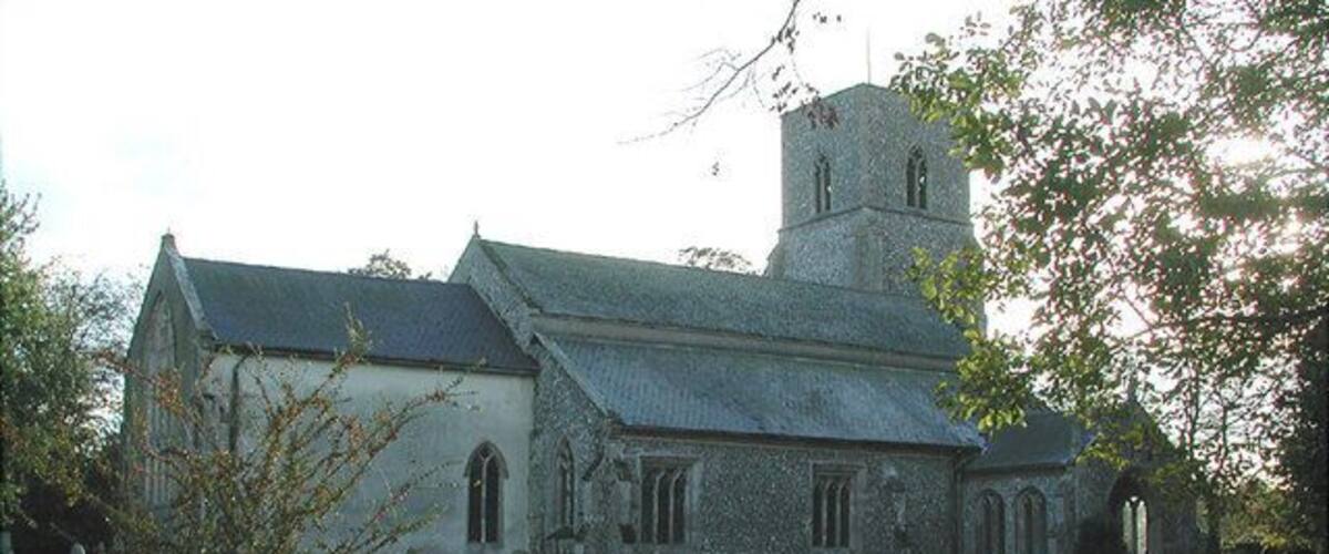 A church with a tower, surrounded by a cemetery with headstones.