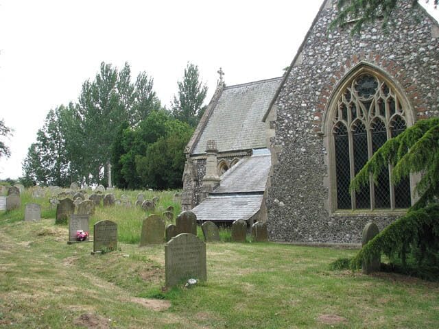 St Michael's church in Geldeston - churchyard Headstones by the north transept. St Michael's church https://www.geograph.org.uk/photo/1342904 has been built into a hill beside Yarmouth Road. The round tower dates from the 12th century but after a Victorian restoration, the rebuilding of the chancel and the addition of a north transept in 1864 not many original features remain. The porch is medieval as is the baptismal font > https://www.geograph.org.uk/photo/1971173. pulpit and benches date from the 19th century and the unusual east window > https://www.geograph.org.uk/photo/1971164 - by Leonard Walter - was installed in the 20th century.