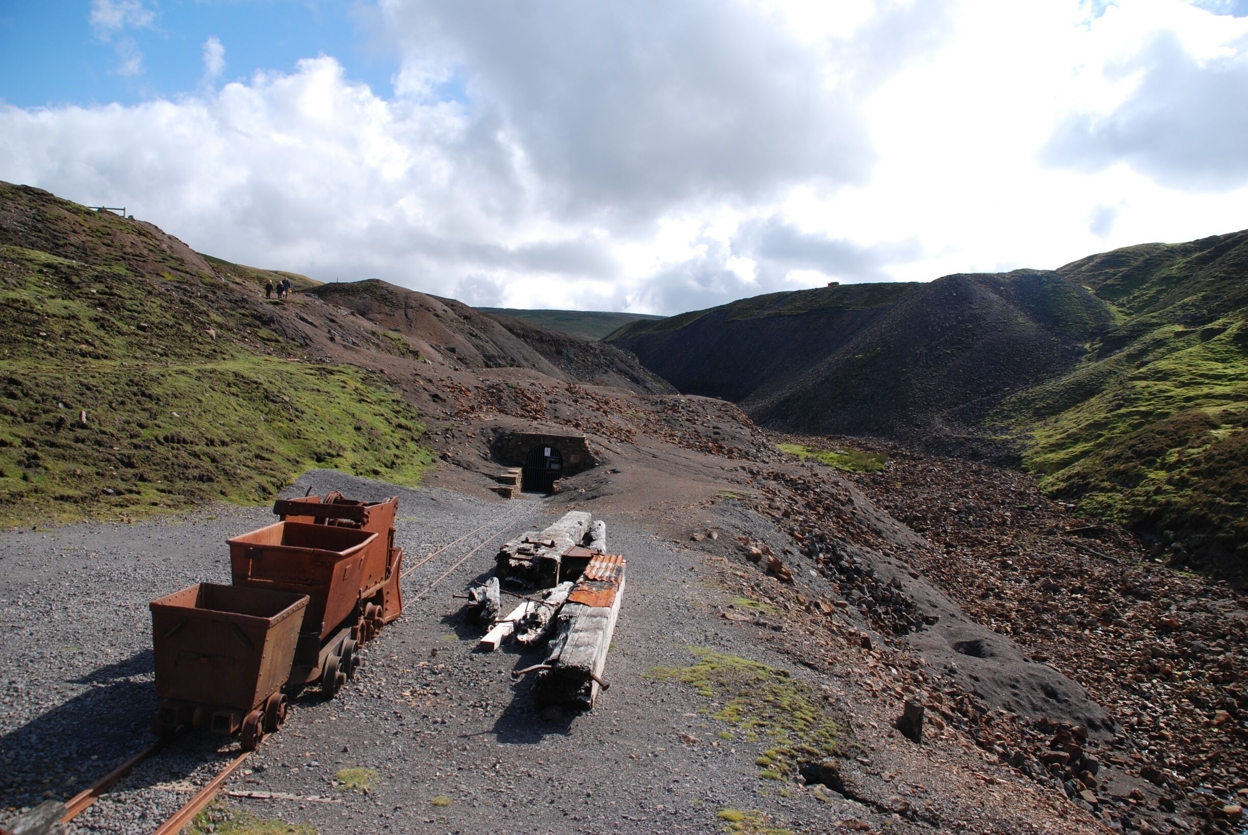 A railway track with a train car and a caboose in a mountainous area.