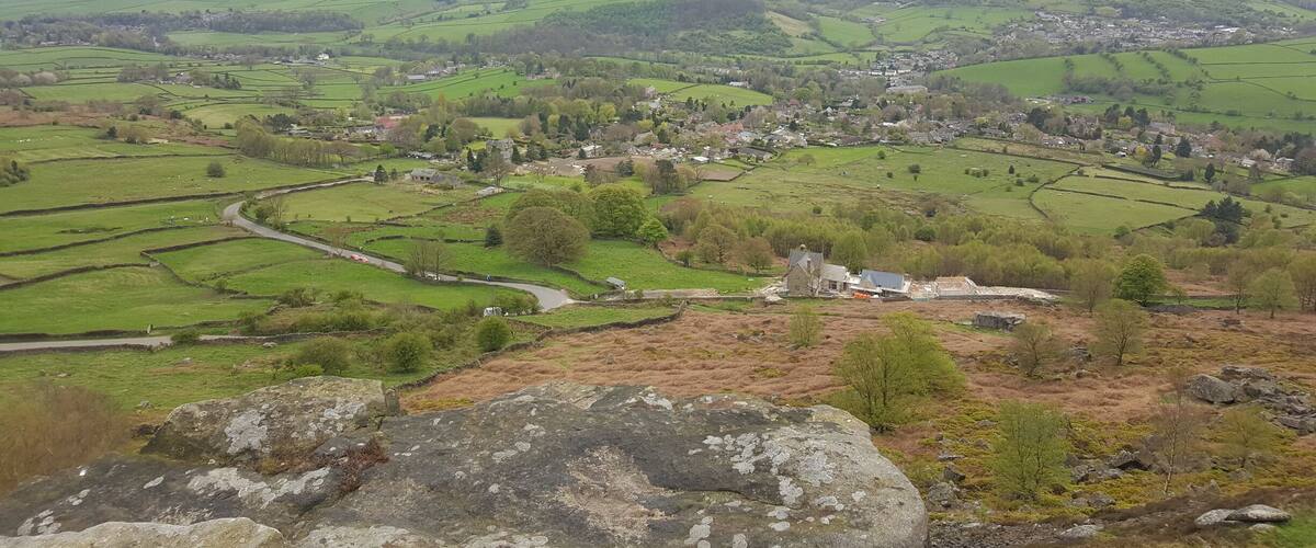 A rural landscape with rolling hills, fields, and a small village.