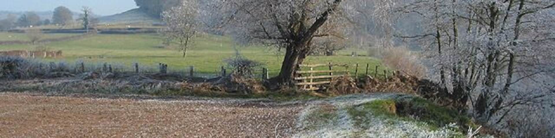 Riverside footpath approaching a stile Capler Wood in the distance. The River Wye flows downstream to the right. Farmland to the left. 20 minutes to noon and still the frost lingers.