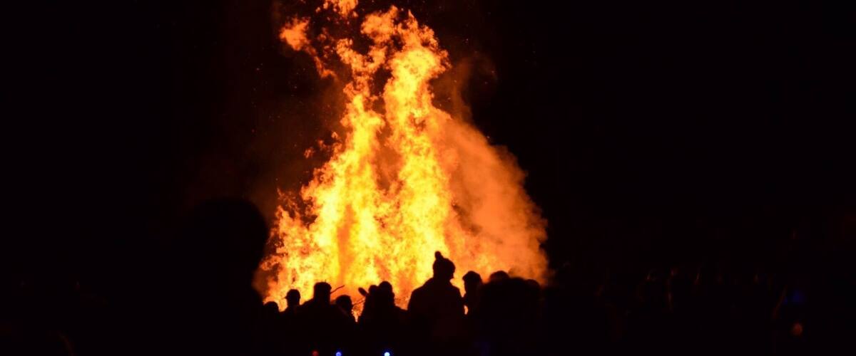 A large fire with smoke rising into the night sky.