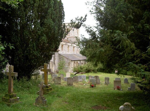 A cemetery with gravestones and a church in the background.