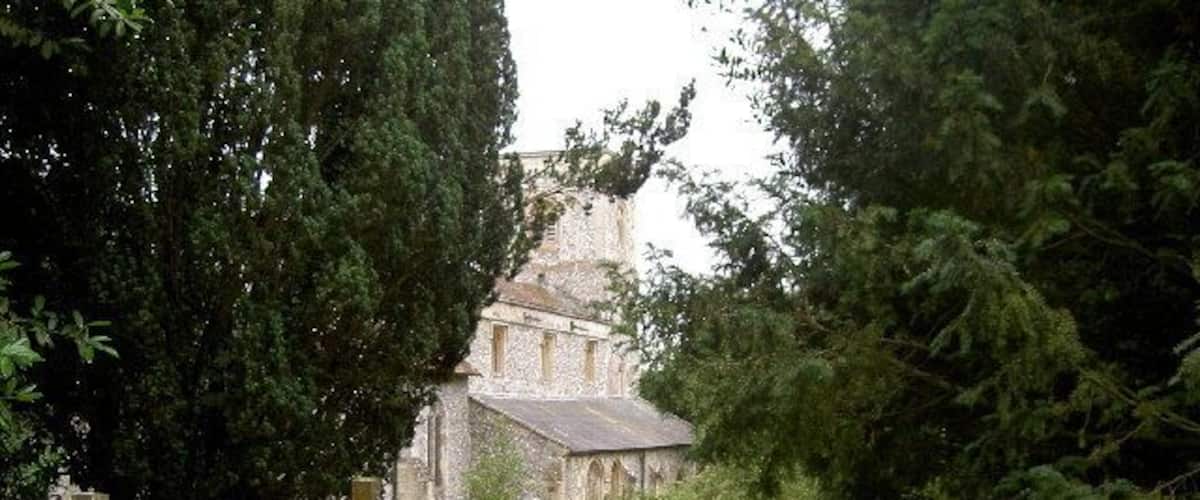 A cemetery with gravestones and a church in the background.