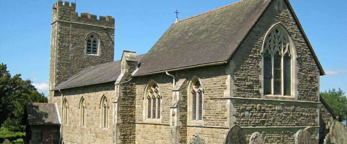 A stone church with a tower and arched windows.