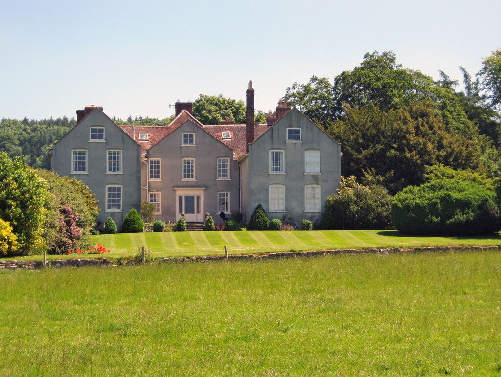 "From the park looking east to the ha-ha, lawn and the ends of the two wings. The main entrance is on the right. May have been the site of a Medieval building, but by 1655 it came into the hands of the Walcot family, who were Royalists with very close ties to Charles I. In 1766, the house was was completely redesigned and redecorated by Thomas Farnolls Pritchard. Since 1901 it has been owned by the Wheeler family."[1]