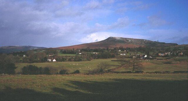 Clee Hill from Knowbury. Just north of Knowbury, a patchwork of small fields on poor quality farmland. There were many small holdings here, often belonging to miners. The area is occasionally threatened by open cast operators.