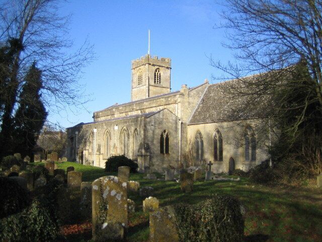 A historic church with a tall tower and arched windows, surrounded by a cemetery.