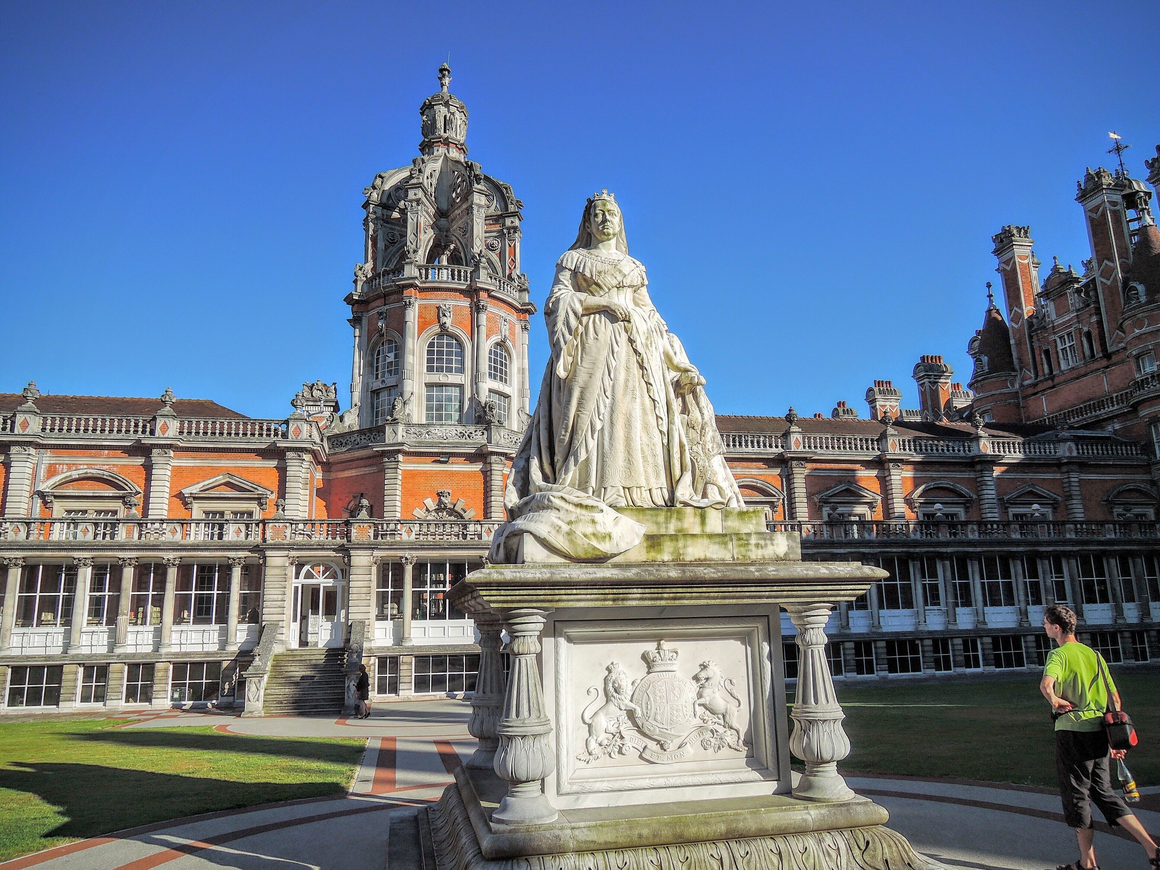 A large statue in front of a historic building with ornate architecture.
