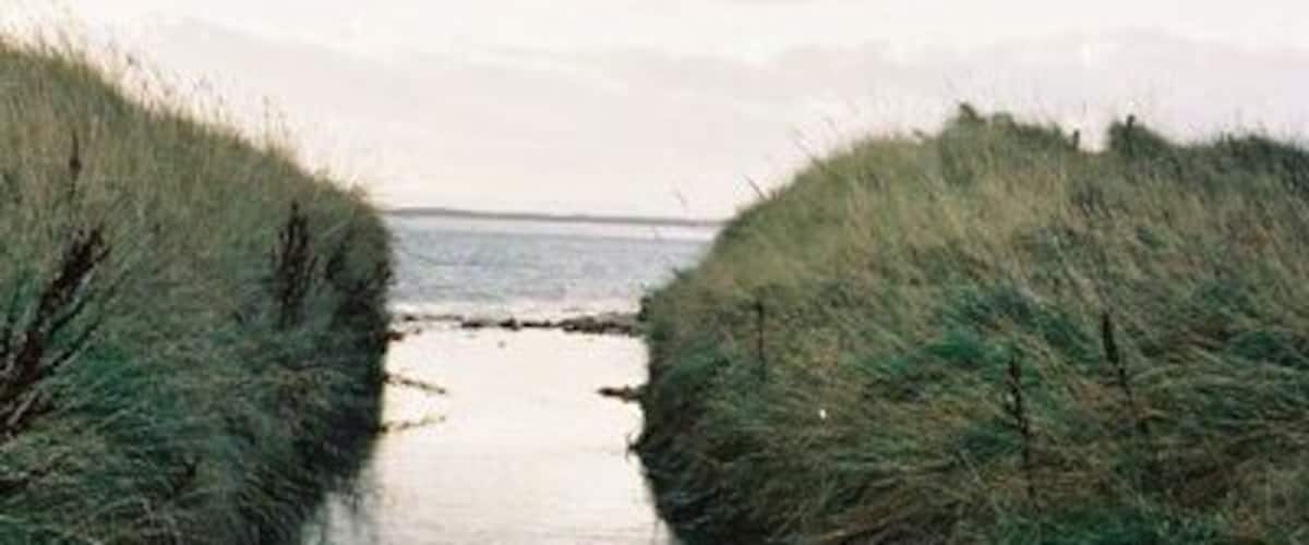 A narrow water channel flanked by grassy banks.